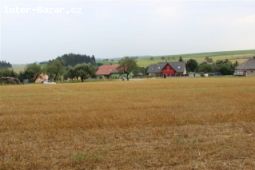 Pozemky na kraji vesničky u lesa.